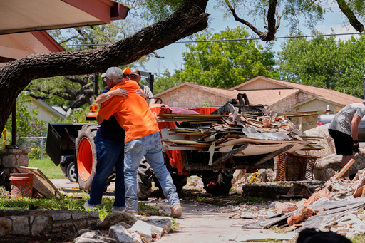 FILE - Homeowner Daniel Olivas hugs Lorrie McMillan, a chaplain with Texans on Mission Disaster Relief, as he clears debris from his home, which was heavily damaged from flash floods along the Guadalupe River in Kerrville, Texas, July 10, 2025. (AP Photo/Gerald Herbert, File) FILE - Homeowner Daniel Olivas hugs Lorrie McMillan, a chaplain with Texans on Mission Disaster Relief, as he clears debris from his home, which was heavily damaged from flash floods along the Guadalupe River in Kerrville, Texas, July 10, 2025. (AP Photo/Gerald Herbert, File)