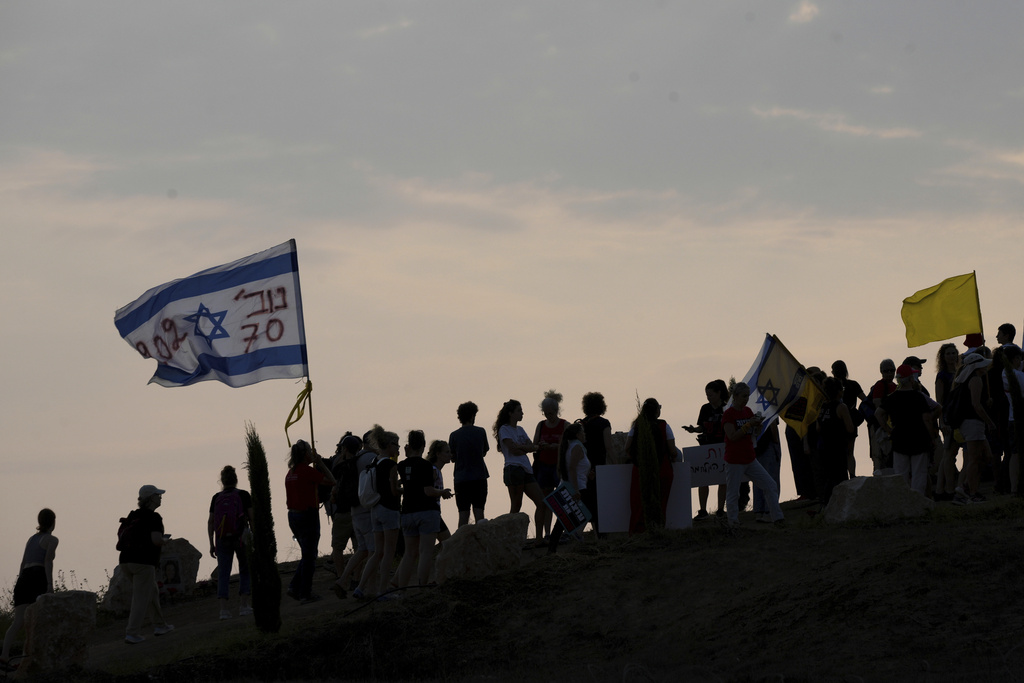 Demonstrators march near the border with Gaza calling for the release of all hostages held by Hamas and for an end to the ongoing war, in southern Israel, Sunday, Aug. 10, 2025. (AP Photo/Ohad Zwigenberg)