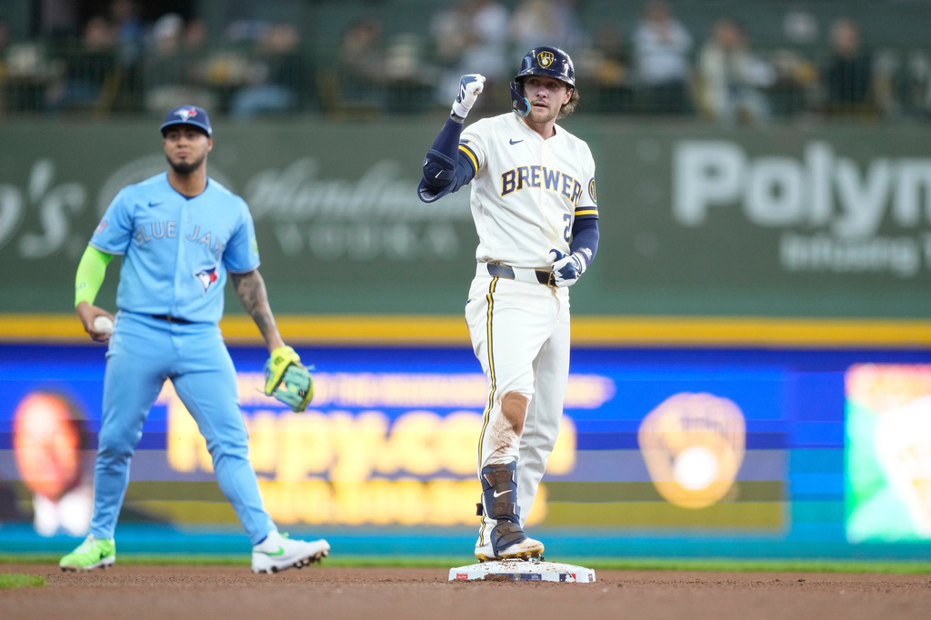 Milwaukee Brewers' Brice Turang, right, reacts after hitting a double during the fourth inning of a baseball game as Toronto Blue Jays second baseman Lenyn Sosa, left, look on, Thursday, April 16, 2026, in Milwaukee. (AP Photo/Kayla Wolf)