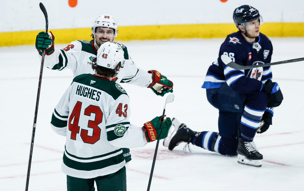 Minnesota Wild's Mats Zuccarello (36) and Quinn Hughes (43) celebrate after Zuccarello's tying goal against the Winnipeg Jets during third-period NHL hockey game action in Winnipeg, Manitoba, Saturday, Dec. 27, 2025. (John Woods/The Canadian Press via AP)