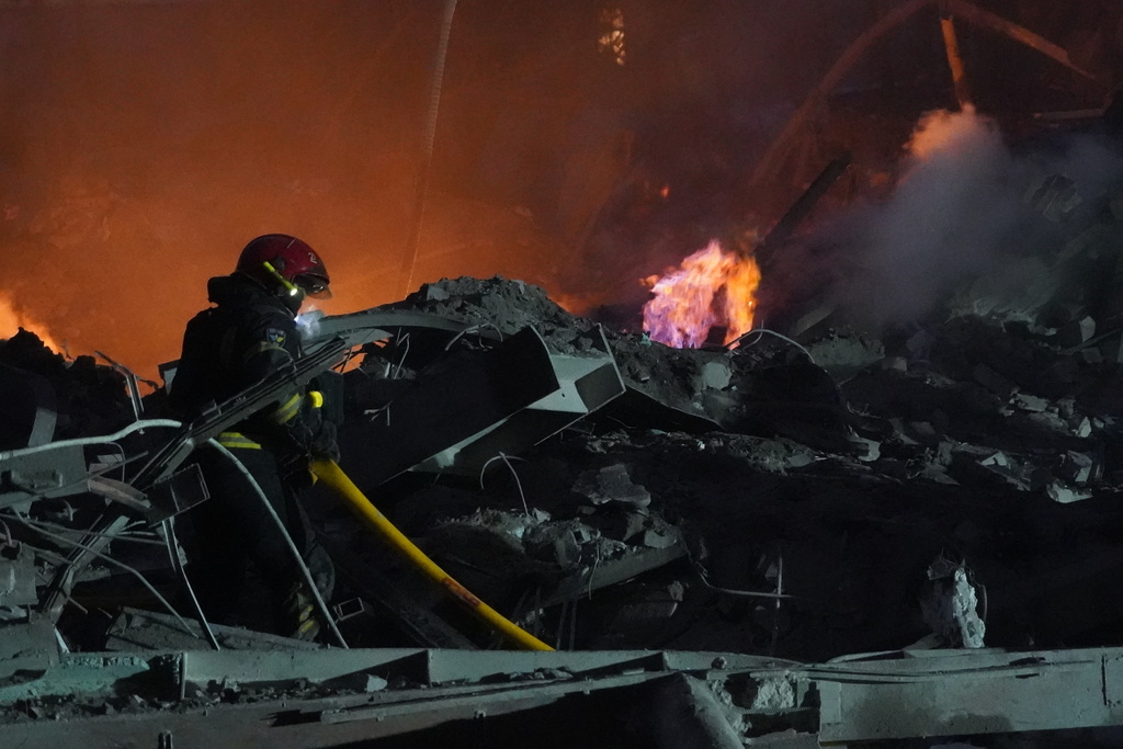 Emergency services personnel work to extinguish a fire following a Russian missile attack in Kharkiv, Ukraine, Friday, Jan. 2, 2026.(AP Photo/Andrii Marienko)