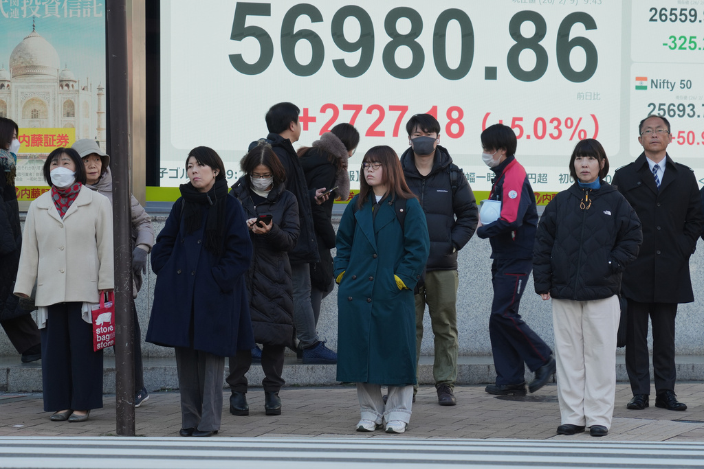 People stand in front of an electronic stock board showing Japan's Nikkei index at a securities firm, Monday, Feb. 9, 2026, in Tokyo. (AP Photo/Eugene Hoshiko)