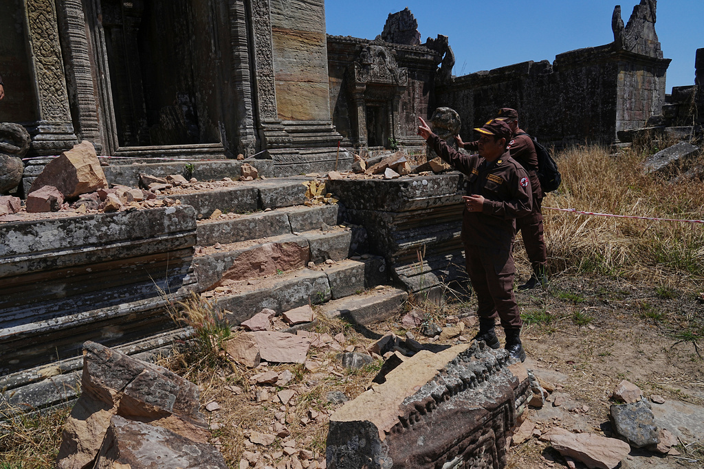 Cambodian Mine Action Center, CMAC, members stand near a temple damaged during border clashes with Thailand, at Preah Vihear province, Cambodia, Saturday, March 14, 2026. (AP Photo/Heng Sinith)