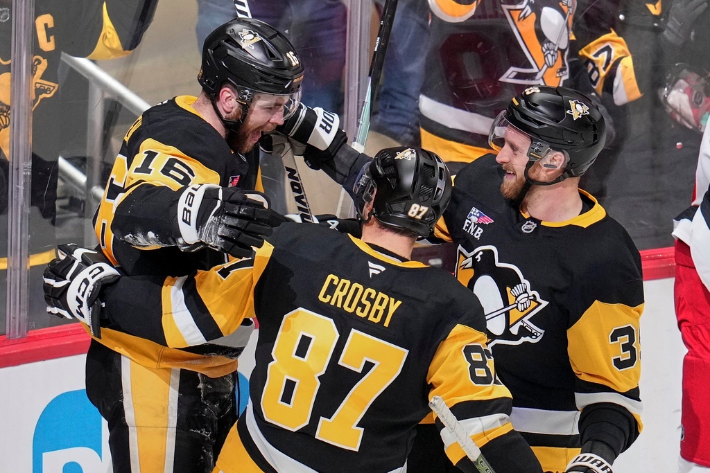 Pittsburgh Penguins' Justin Brazeau (16) celebrates his goal with Sidney Crosby (87) and Anthony Mantha during the first period of an NHL hockey game against the Carolina Hurricanes in Pittsburgh, Tuesday, Dec. 30, 2025. (AP Photo/Gene J. Puskar)