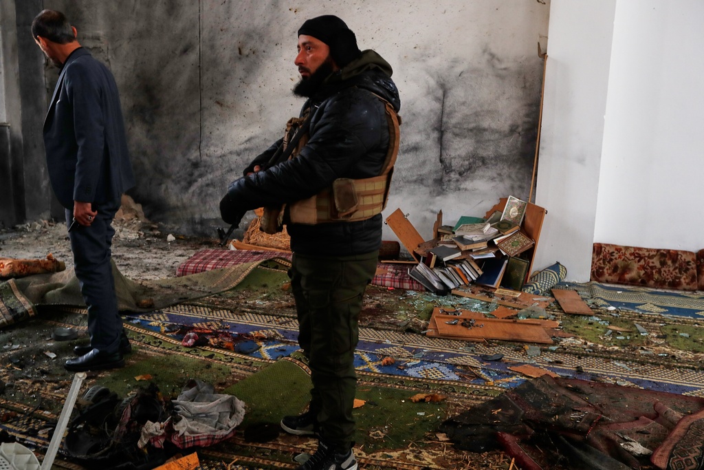 Syrian security officers inspect the site of an attack a day earlier at the Imam Ali bin Abi Talib Mosque in the predominantly Alawite Wadi al-Dhahab neighborhood of Homs, Syria, Saturday, Dec. 27, 2025. (AP Photo/Omar Sanadiki)