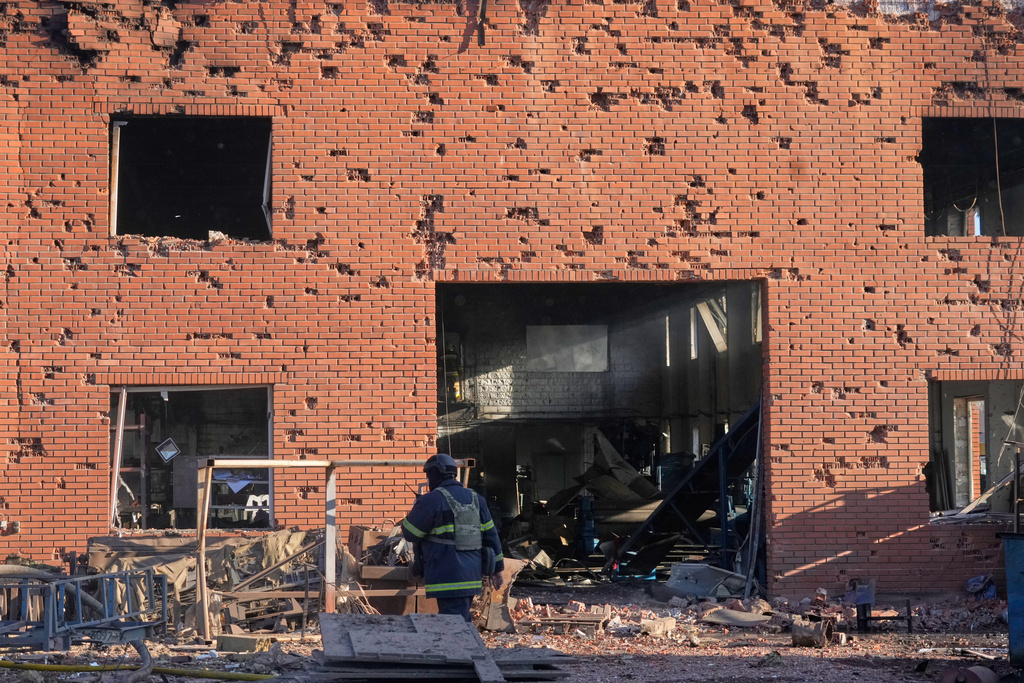 Shrapnel holes cover the wall of the damaged railway workshops, following a Russia missile and drone attack, in Brovary close to Kyiv, Ukraine, Saturday, March 14, 2026. (AP Photo/Efrem Lukatsky)