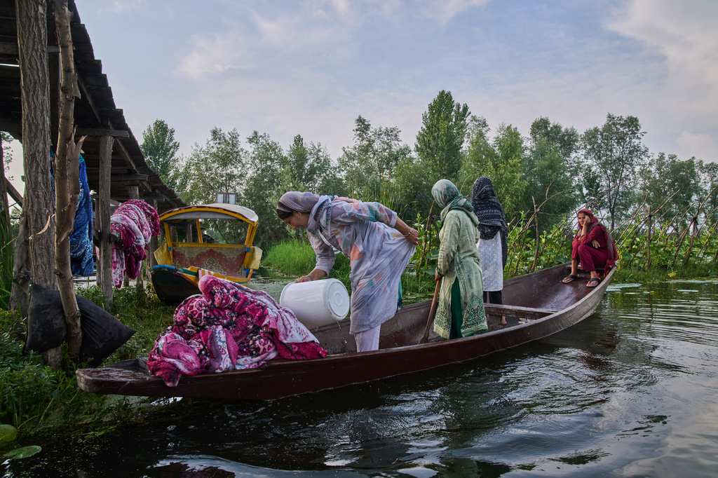 Kashmiri women on a boat wash blankets in the interiors of Dal Lake in Srinagar, Monday, June 1, 2026. (AP Photo/Dar Yasin)