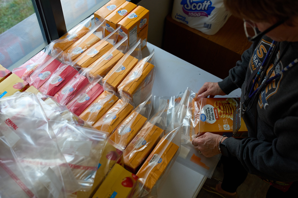 Jen Janecek Hartman helps prepare bagged meals for a food bank for students at Nueta Hidatsa Sahnish College, Thursday, Oct. 30, 2025, in New Town, N.D. (AP Photo/John Locher)