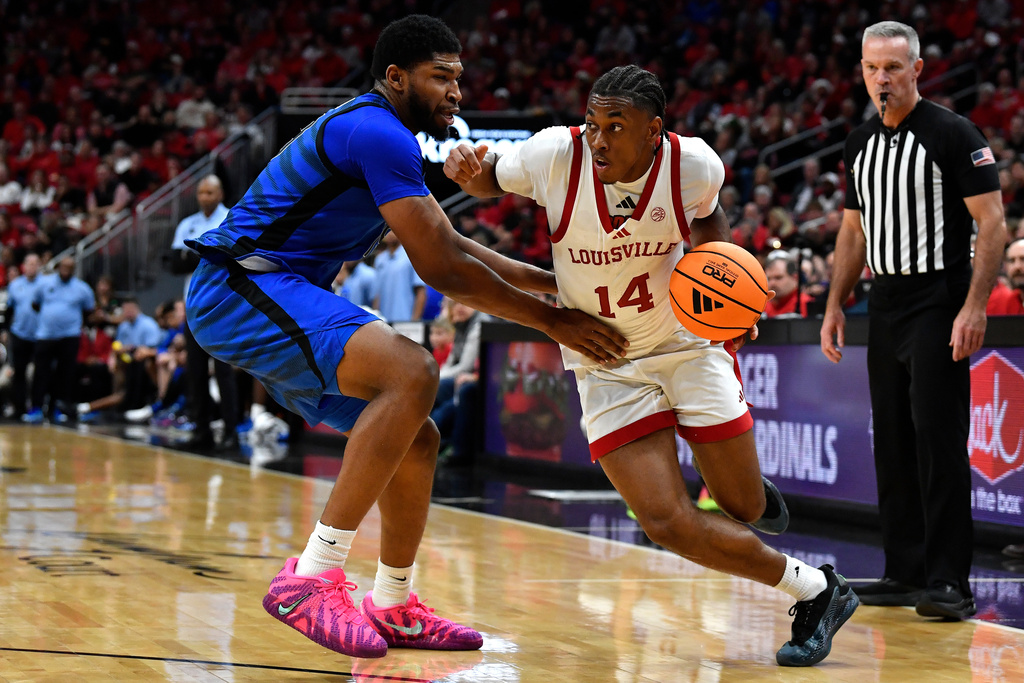 Louisville guard Adrian Wooley (14) attempts to get past Memphis forward Tariq Ingraham, left, during the second half of an NCAA college basketball game in Louisville, Ky., Saturday, Dec. 13, 2025. (AP Photo/Timothy D. Easley)