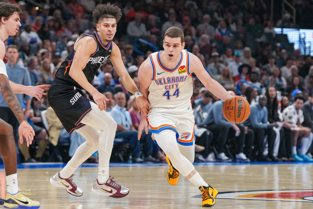 Oklahoma City Thunder guard Nikola Topic, right, drives past Phoenix Suns guard Koby Brea during the second half of an NBA basketball game, Sunday, April 12, 2026, in Oklahoma City. (AP Photo/Kyle Phillips)