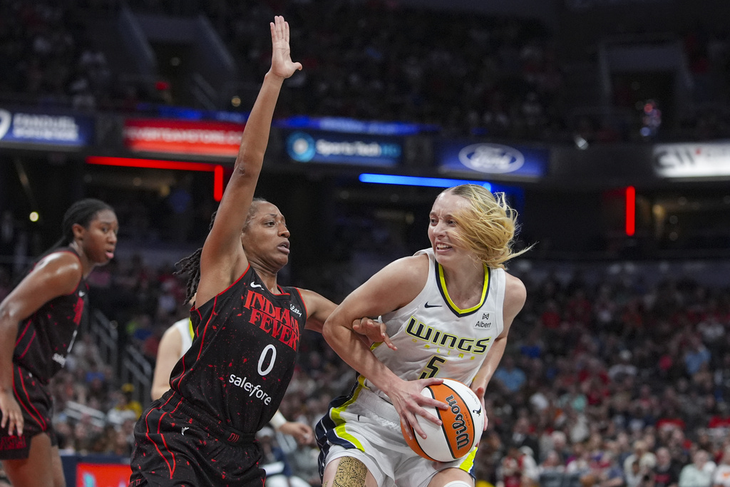 Dallas Wings guard Paige Bueckers (5) looks to shoot over Indiana Fever guard Kelsey Mitchell (0) in the first half of a WNBA basketball game in Indianapolis, Tuesday, Aug. 12, 2025. (AP Photo/Michael Conroy)