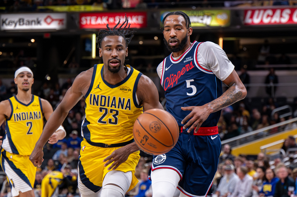 Indiana Pacers guard Aaron Nesmith (23) and Los Angeles Clippers forward Derrick Jones Jr. (5) chase the ball during the first half of an NBA basketball game in Indianapolis, Friday, March 27, 2026. (AP Photo/Doug McSchooler)