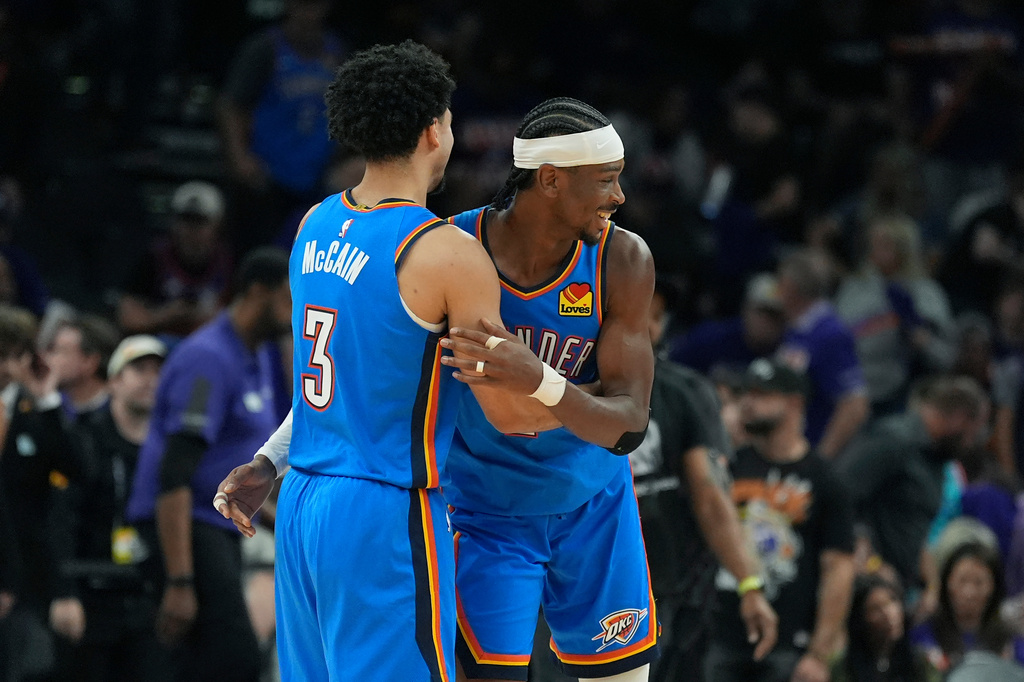 Oklahoma City Thunder guards Shai Gilgeous-Alexander, right, and Jared McCain (3) celebrate as time winds down during the second half of Game 3 of a first-round NBA playoffs basketball series against the Phoenix Suns, Saturday, April 25, 2026, in Phoenix. (AP Photo/Ross D. Franklin)