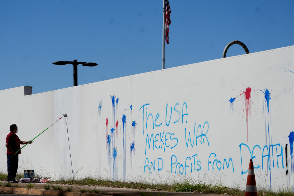 A worker paints to remove protest graffiti on a wall of the U.S. Embassy in Brasília, Brazil, Thursday, Aug. 13, 2026. (AP Photo/Eraldo Peres)