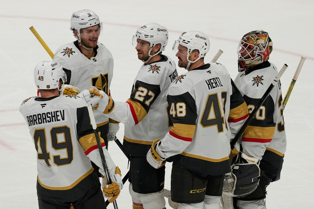 Vegas Golden Knights defenseman Shea Theodore, middle, is congratulated by teammates after scoring an empty net goal during the third period of an NHL hockey game against the San Jose Sharks in San Jose, Calif., Sunday, Jan. 11, 2026. (AP Photo/Jeff Chiu)