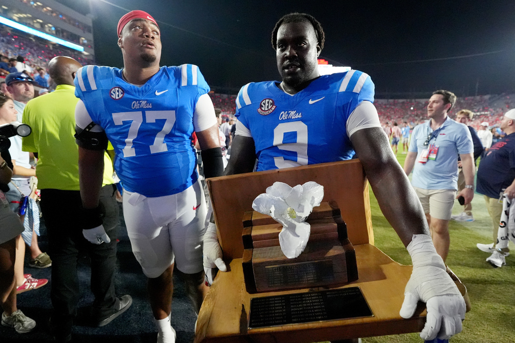 Mississippi offensive lineman Enoch Wangoy (77) and defensive tackle Jehiem Oatis (9) carry the "Magnolia Bowl" trophy as they celebrate their team's win over LSU in an NCAA college football game in Oxford, Miss., Saturday, Sept. 19, 2026. (AP Photo/Rogelio V. Solis)