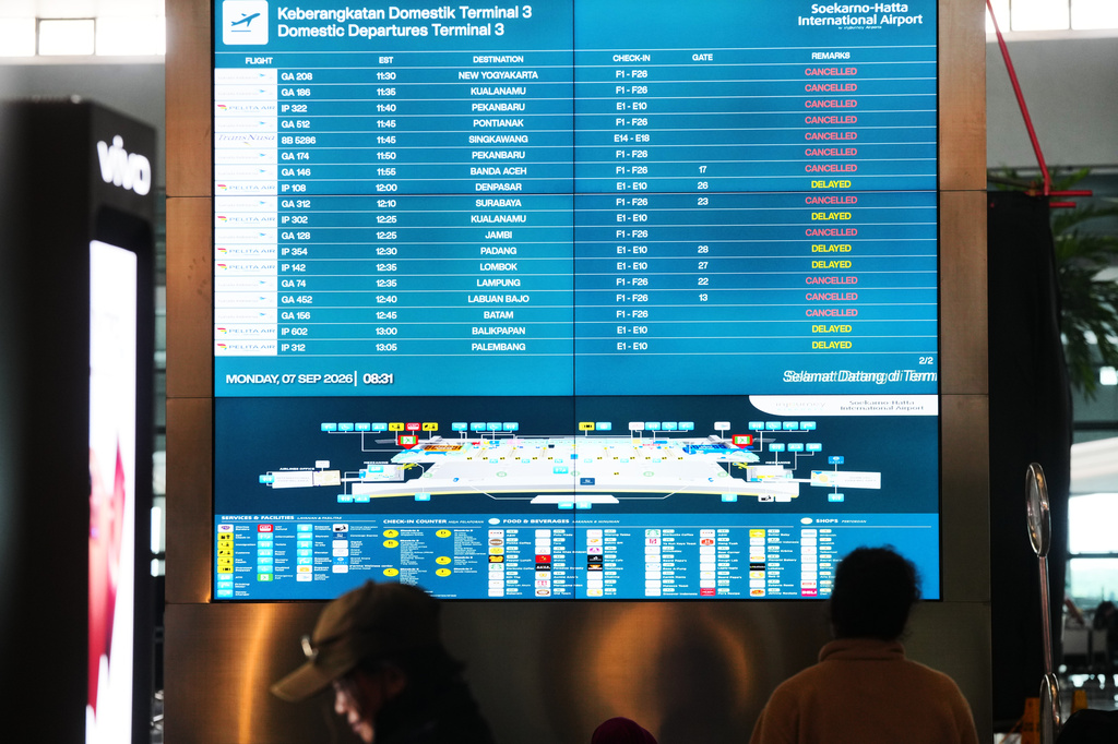 People look at an information board as flights are disrupted due to the eruption of Mount Anak Krakatau, at Soekarno-Hatta International Airport in Tangerang, Indonesia, Monday, Sept. 7, 2026. (AP Photo/Tatan Syuflana)