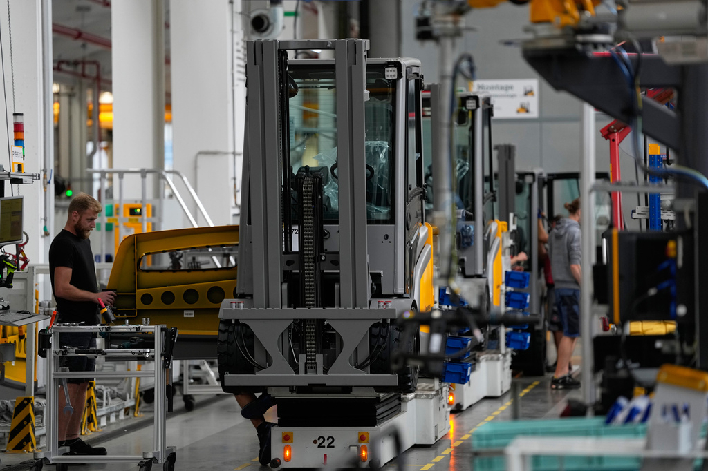 Employees at forklift and warehouse vehicle manufacturer Jungheinrich work on the assembly line in Moosburg, Germany, Tuesday, Aug. 25, 2026. (AP Photo/Matthias Schrader)