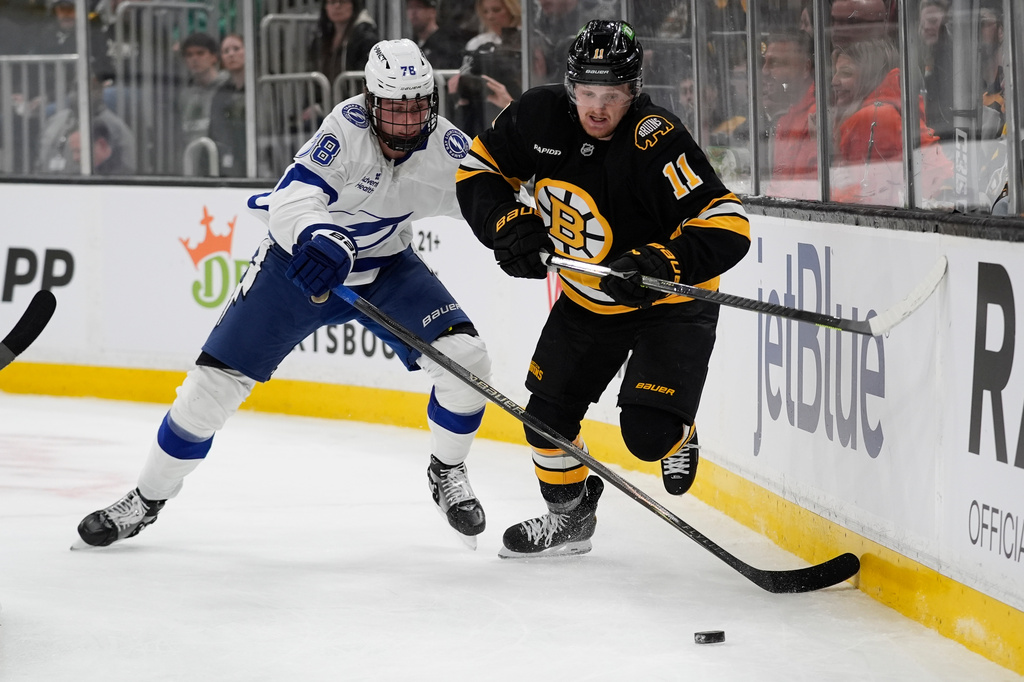 Boston Bruins center Casey Mittelstadt (11) and Tampa Bay Lightning defenseman Emil Lilleberg (78) chase the puck behind the Lightning net during the first period of an NHL hockey game, Saturday, April 11, 2026, in Boston. (AP Photo/Robert F. Bukaty)