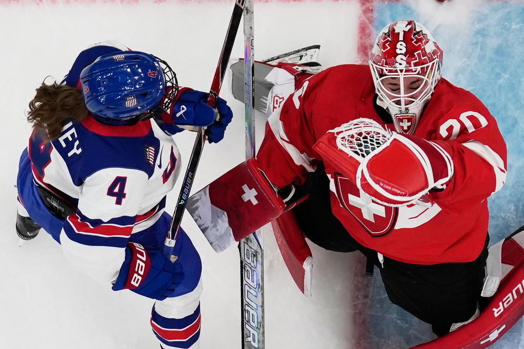 Switzerland's Andrea Brandli makes a save against United States' Caroline Harvey during a preliminary round match of women's ice hockey between the United States and Switzerland at the 2026 Winter Olympics, in Milan, Italy, Monday, Feb. 9, 2026. (AP Photo/Petr David Josek)