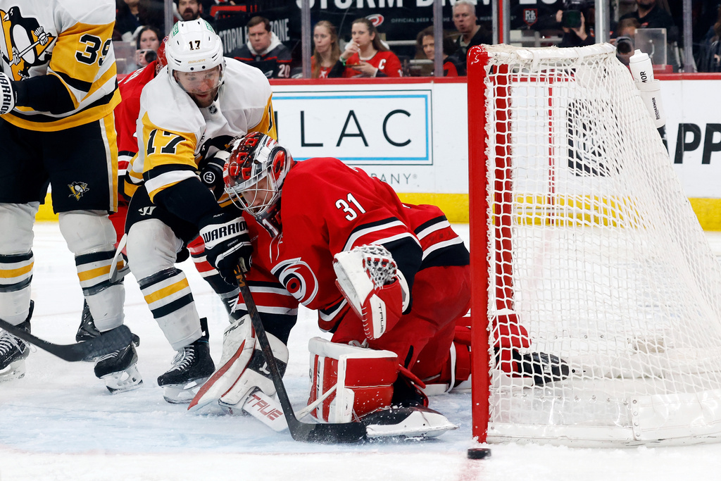 Pittsburgh Penguins' Bryan Rust (17) looses control of the puck as he collides with Carolina Hurricanes goaltender Frederik Andersen (31) during the third period of an NHL hockey game in Raleigh, N.C., Wednesday, March 18, 2026. (AP Photo/Karl DeBlaker)