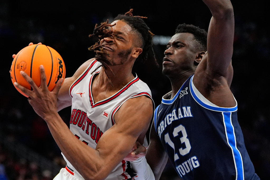 Houston's Joseph Tugler, left, drives past BYU's Keba Keita during the second half of an NCAA college basketball game in the quarterfinal round of the Big 12 Conference tournament Thursday, March 12, 2026, in Kansas City, Mo. (AP Photo/Charlie Riedel)