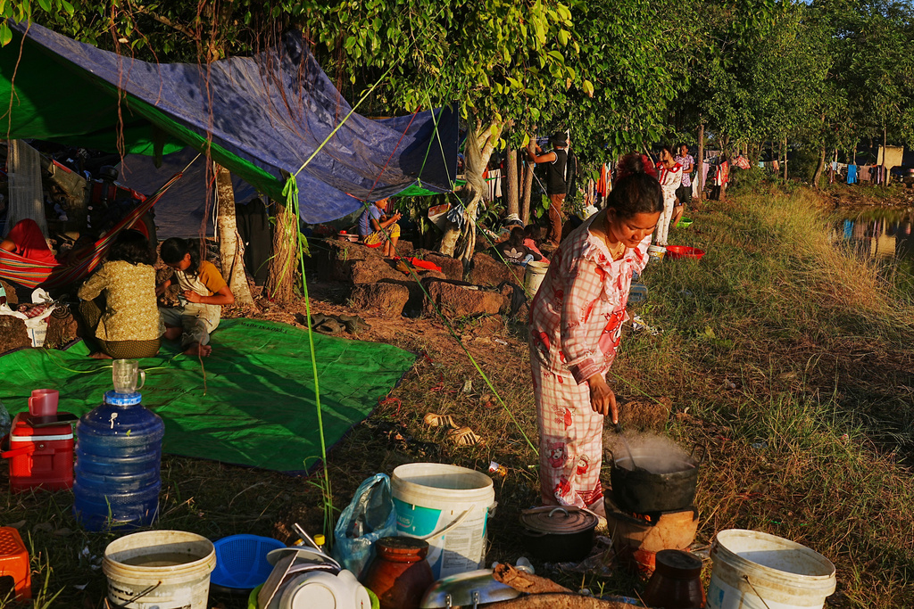 People prepare breakfast as they take refuge at Wat Chroy Neangoun's Buddhist pagoda in Siem Reap province, Cambodia Friday, Dec. 12, 2025, after fleeing from home following fighting between Thailand and Cambodia over territorial claims. (AP Photo/Heng Sinith)