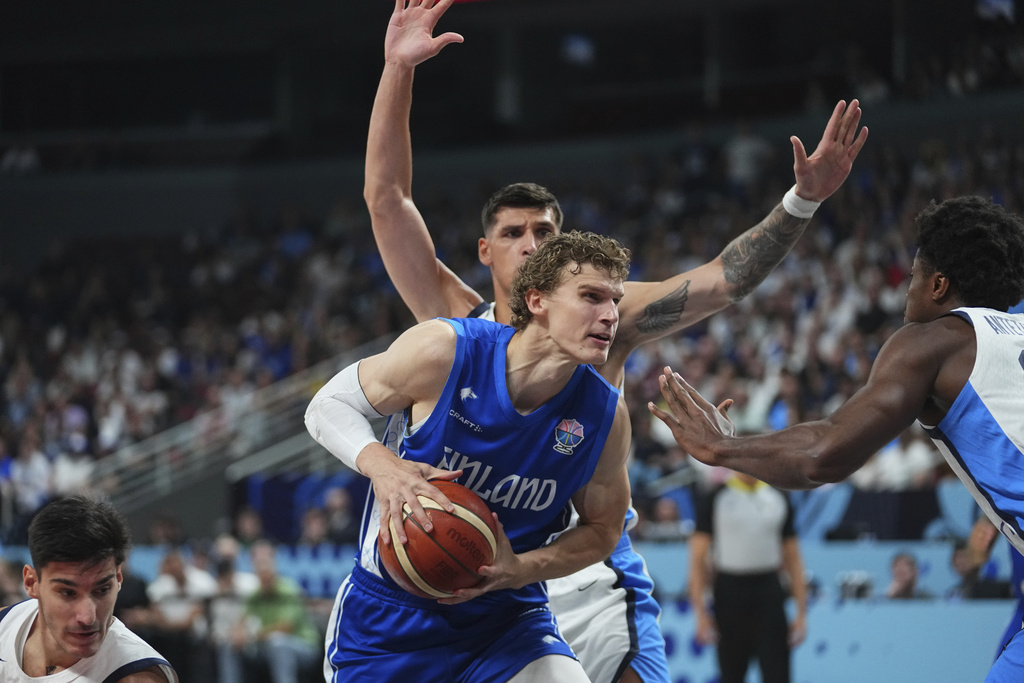 Finland's Lauri Markkanen, centre, tries to shoot while defended by Greece's Kostas Antetokounmpo during the Eurobasket, European Basketball Championship third place match between Greece and Finland at the Riga Arena in Riga, Latvia, Sunday, Sept. 14, 2025. (AP Photo/Sergei Grits)