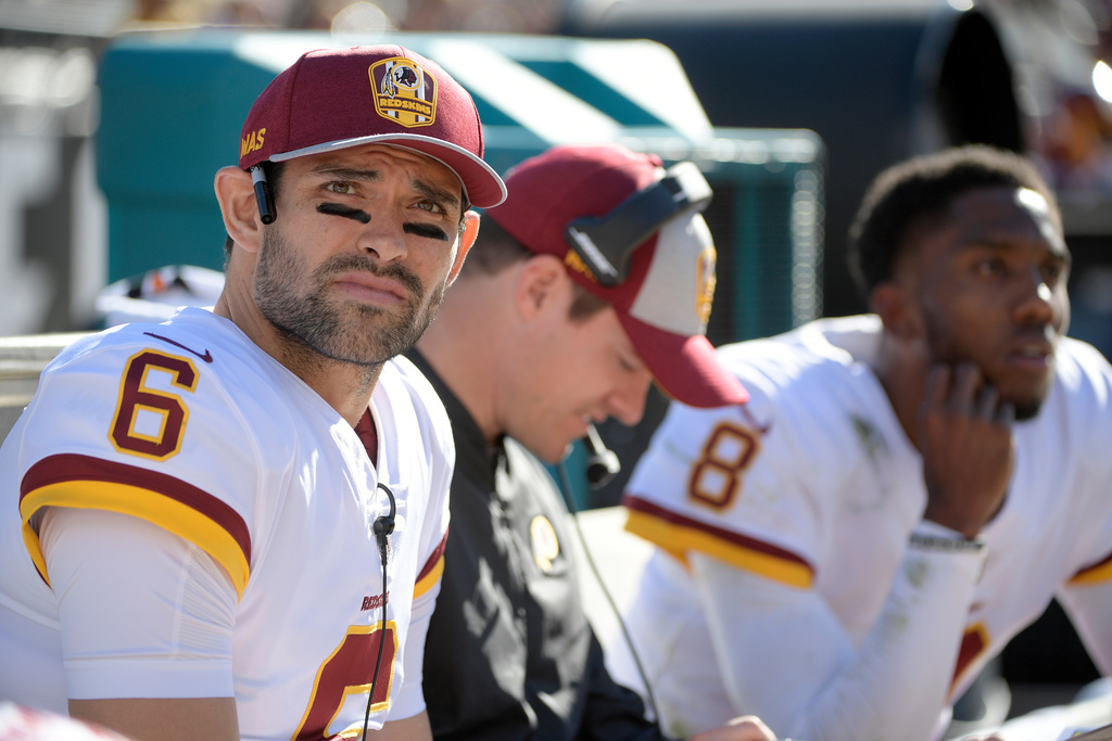 FILE - Washington Redskins quarterback Mark Sanchez (6) watches from the bench with passing game coordinator Kevin O'Connell, center, and quarterback Josh Johnson (8) during the first half of an NFL football game against the Jacksonville Jaguars Sunday, Dec. 16, 2018, in Jacksonville, Fla. (AP Photo/Phelan M. Ebenhack, File)