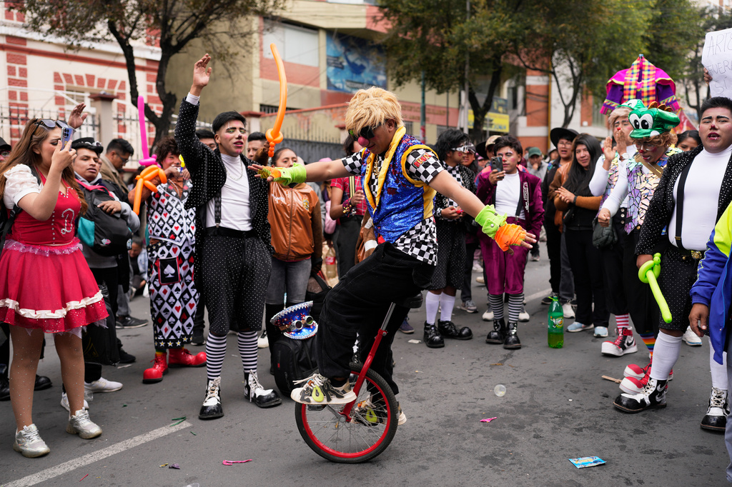 A clown rides a unicycle during a protest against the government's ban on holiday parties at schools during teaching hours, outside the Ministry of Education in La Paz, Bolivia, Monday, March 30, 2026. (AP Photo/Juan Karita)