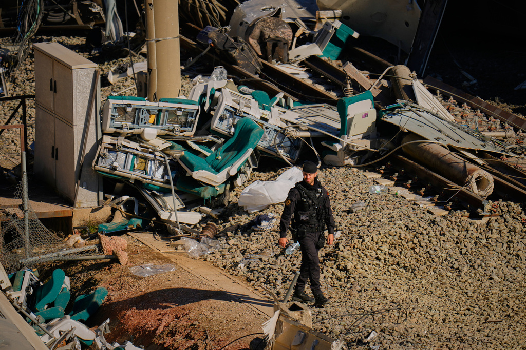 Guardia Civil officers collect evidence next to the wreckage of train cars involved in a collision in Adamuz, southern Spain, Tuesday, Jan. 20, 2026. (AP Photo/Manu Fernandez)