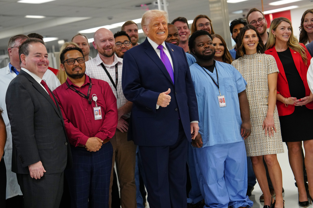 President Donald Trump poses for a photo with workers as he visits Thermo Fisher Scientific, Wednesday, March 11, 2026, in Cincinnati. (AP Photo/Julia Demaree Nikhinson)