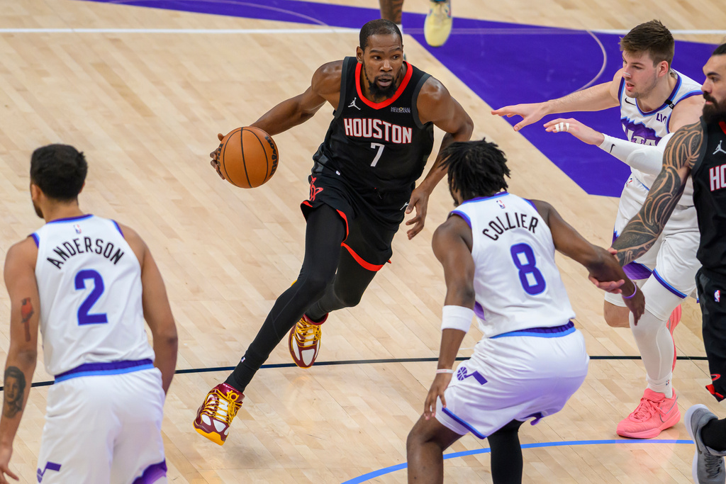 Houston Rockets forward Kevin Durant (7) drives to the basket guarded by Utah Jazz guard Isaiah Collier (8) during the second half of an NBA basketball game, Sunday, Nov. 30, 2025, in Salt Lake City. (AP Photo/Tyler Tate)