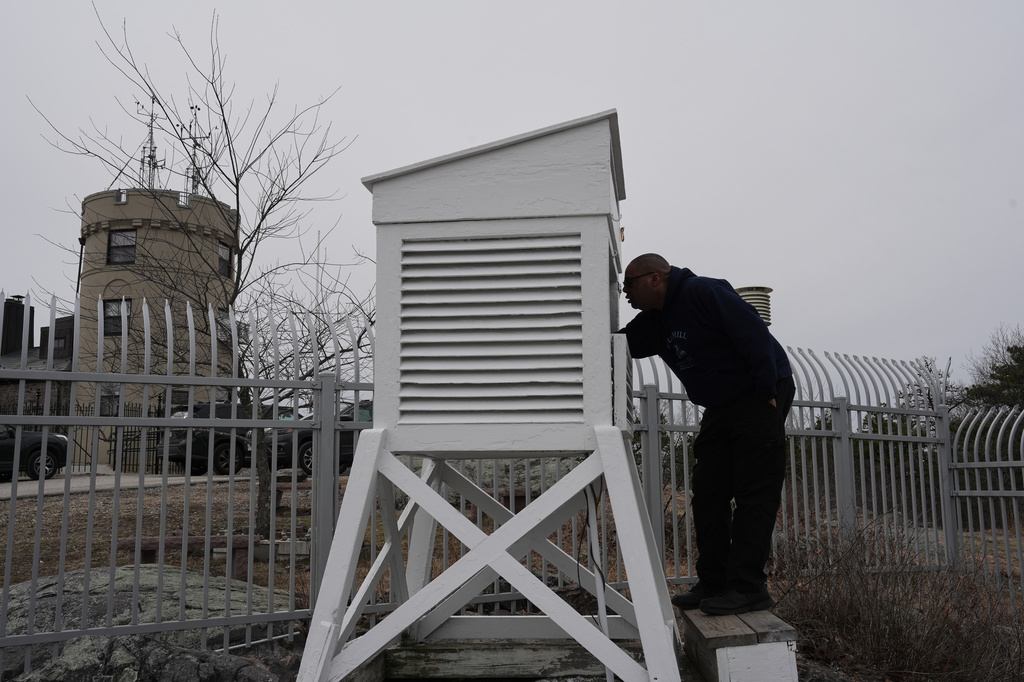 Matthew Douglas, the observatory's chief weather observer, reads temperature and humidity from the thermometers and a psychrometer outside the Blue Hill Observatory and Science Center, Friday, March 13, 2026, in Milton, Mass. (Laura Martin Agudelo/MIT Graduate Program in Science Writing via AP)