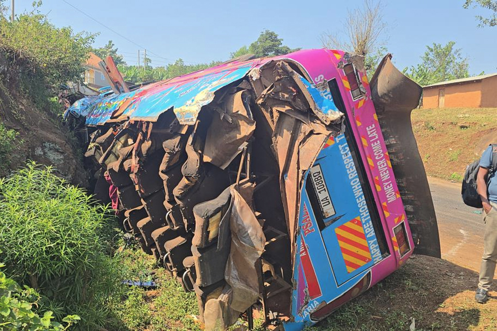 A bus lies on the side of the road Friday, July 17, 2026, after it crashed Thursday night in the the Kapchorwa District in eastern Uganda. (AP Photo)