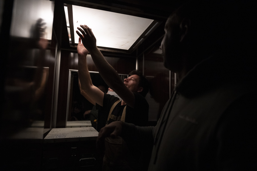 Konstantinos Pantoudis tries to catch a bee in an elevator during a late-night hive transfer in the Ilioupoli suburb of Athens, Greece, May 6, 2025. (AP Photo/Michael Varaklas)