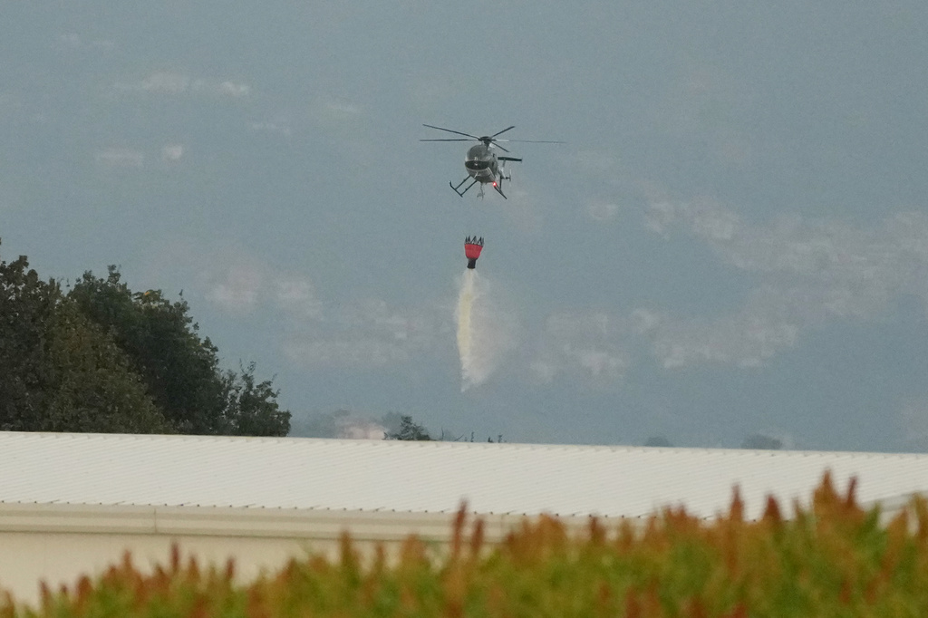A helicopter drops water over the scene of an explosion at an ammunition plant in Colleferro, near Rome, Thursday, Aug. 13, 2026. (AP Photo/Gregorio Borgia)