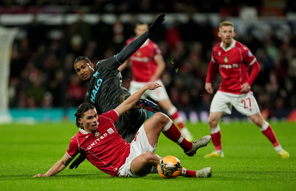 Wrexham's George Dobson, bottom, and Ipswich Town's Jens Cajuste battle for the ball during an English FA Cup fourth round soccer, Friday, Feb. 13, 2026, in Wrexham, Wales. (Martin Rickett/PA via AP)