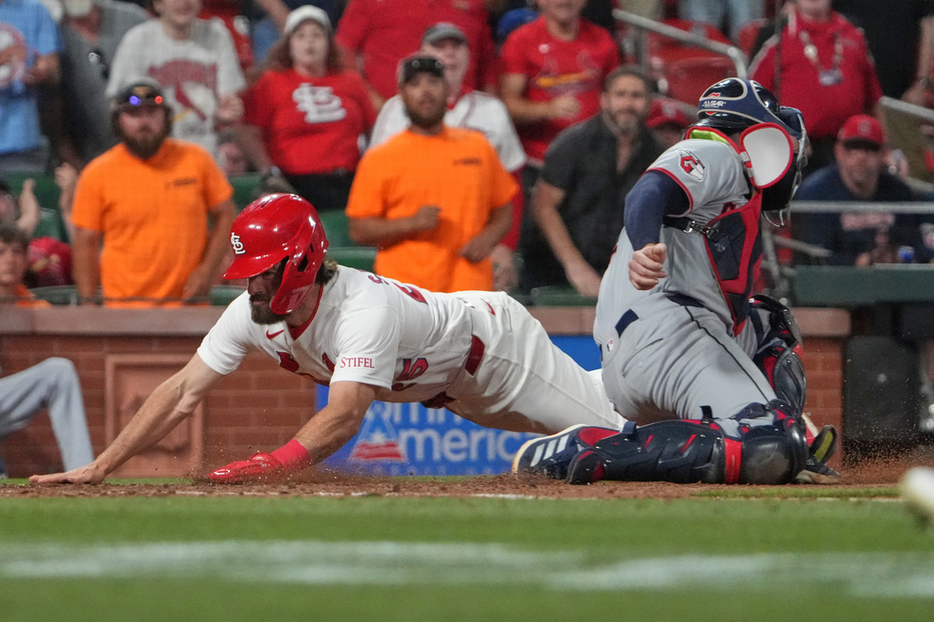 St. Louis Cardinals' Thomas Saggese, left, scores the game-winning run past Cleveland Guardians catcher David Fry during the 10th inning of a baseball game Tuesday, April 14, 2026, in St. Louis. (AP Photo/Jeff Roberson)