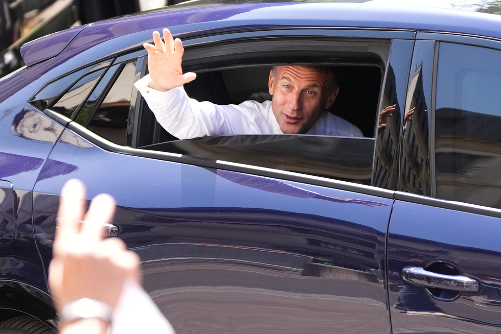 French President Emmanuel Macron waves from a car leaving after meeting security forces ahead of G7 summit in Evian-les-Bains, France, Monday, June 15, 2026. (AP Photo/Christophe Ena)