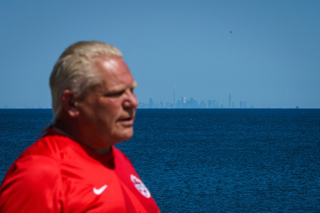 The Toronto skyline is seen across Lake Ontario as Ontario Premier Doug Ford speaks during an interview prior to the unveiling of a sign for Lake Ontario at Fifty Point Conservation Area in Grimsby, Ontario, Canada, on Saturday, Aug. 29, 2026. (Keito Newman/The Canadian Press via AP)