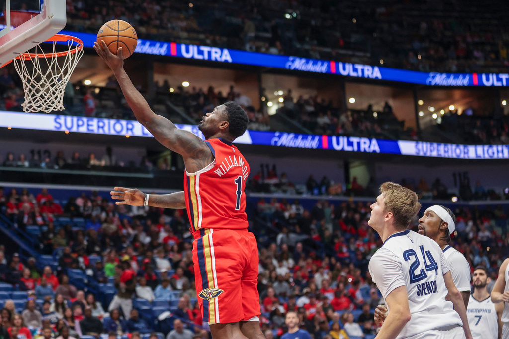 New Orleans Pelicans forward Zion Williamson (1) drives past Memphis Grizzlies guard Cam Spencer (24) to the basket in the first half of an Emirates NBA Cup basketball game, Wednesday, Nov. 26, 2025, in New Orleans. (AP Photo/Peter Forest)