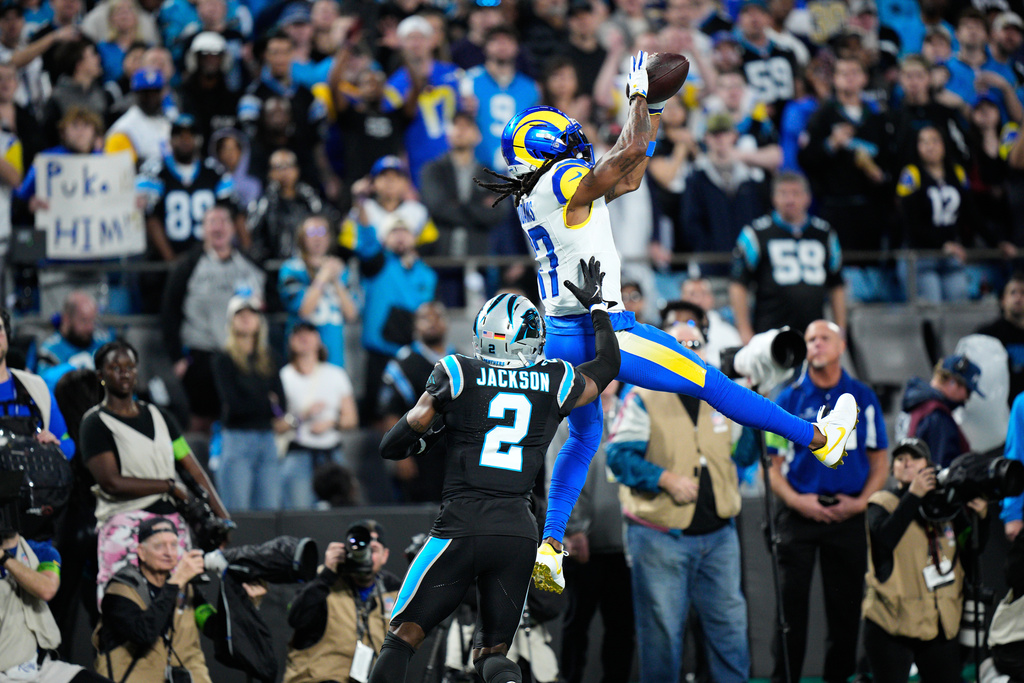Los Angeles Rams wide receiver Davante Adams (17) makes a catch over Carolina Panthers cornerback Mike Jackson (2) during the first half of an NFL wild-card playoff football game, Saturday, Jan. 10, 2026, in Charlotte, N.C. (AP Photo/Jacob Kupferman)
