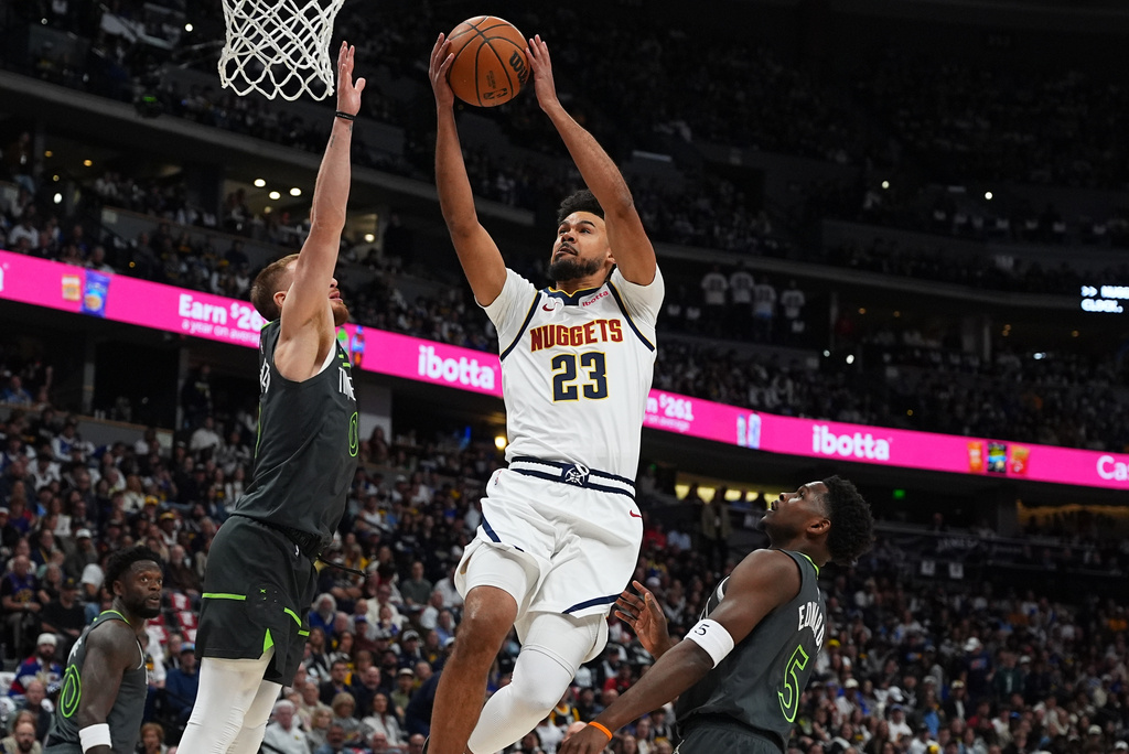 Denver Nuggets forward Cameron Johnson, center, drives to the rim between Minnesota Timberwolves guards Donte DiVincenzo, left, and Anthony Edwards in the first half in Game 1 of a first-round NBA playoffs basketball series, Saturday, April 18, 2026, in Denver. (AP Photo/David Zalubowski)