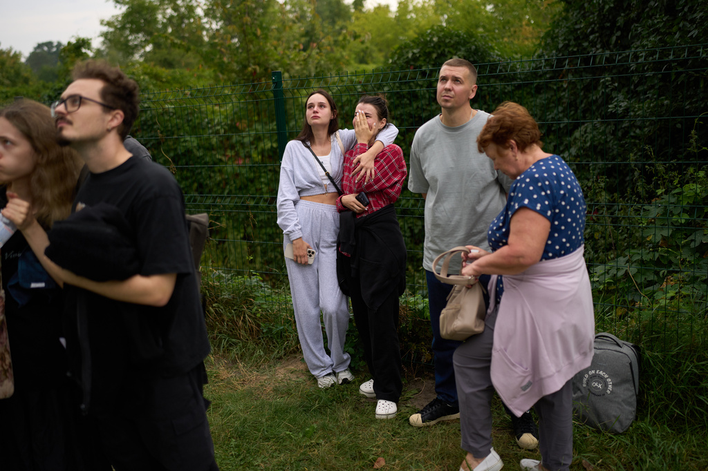 Locals watch as firefighters work after a Russian drone attack struck a residential building in Kyiv, Tuesday, Sept. 1, 2026. (AP Photo/Francisco Seco)
