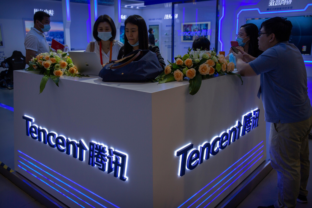 FILE - Visitors gather at a display booth for Chinese technology firm Tencent at the China International Fair for Trade in Services (CIFTIS) in Beijing on Sept. 5, 2020. (AP Photo/Mark Schiefelbein, File)