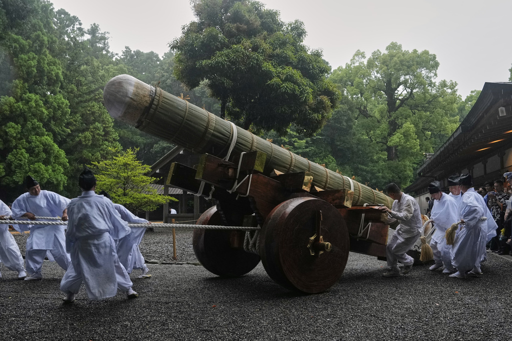Shinto officials in the priesthood pull a sacred timber on a wheeled platform into a position before unloading and moving it under the roof at the end of Mihishirogi Hoeishiki, a ceremony of the Shikinen Sengu ritual to rebuild main structures of the Jingu shrine complex for Shinto deities, at Toyoukedaijingu, also known as Geku, or the outer sanctuary of Jingu, in Ise, central Japan, Tuesday, June 10, 2025, after the cypress timbers were transported from Nagano prefecture's Kiso region to the city. (AP Photo/Hiro Komae)