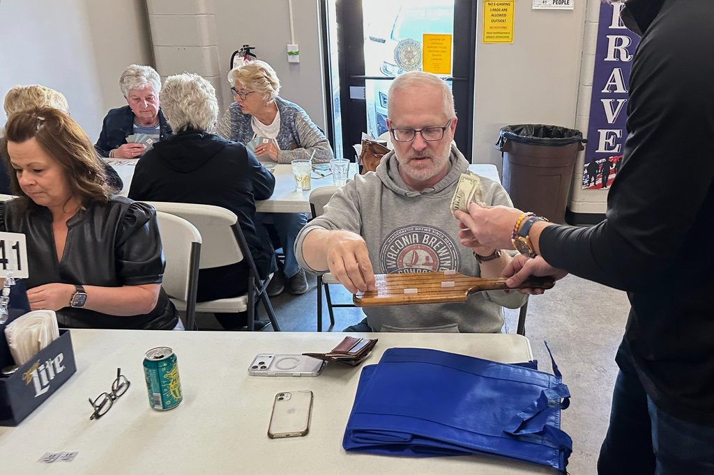 Minnesota state Rep. Jim Nash, R-Waconia, right, buys tickets for the weekly meat raffle April 10, 2026, at American Legion Post 150 in Waconia, Minn. (AP Photo/Steve Karnowski)