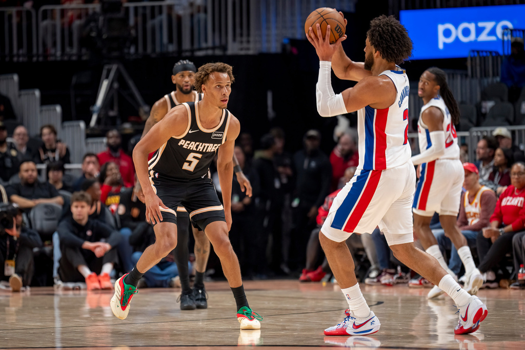 Atlanta Hawks guard Dyson Daniels (5) defends the goal against Detroit Pistons guard Cade Cunningham during the first half of an NBA basketball game, Tuesday, Nov. 18, 2025, in Atlanta. (AP Photo/Erik Rank)