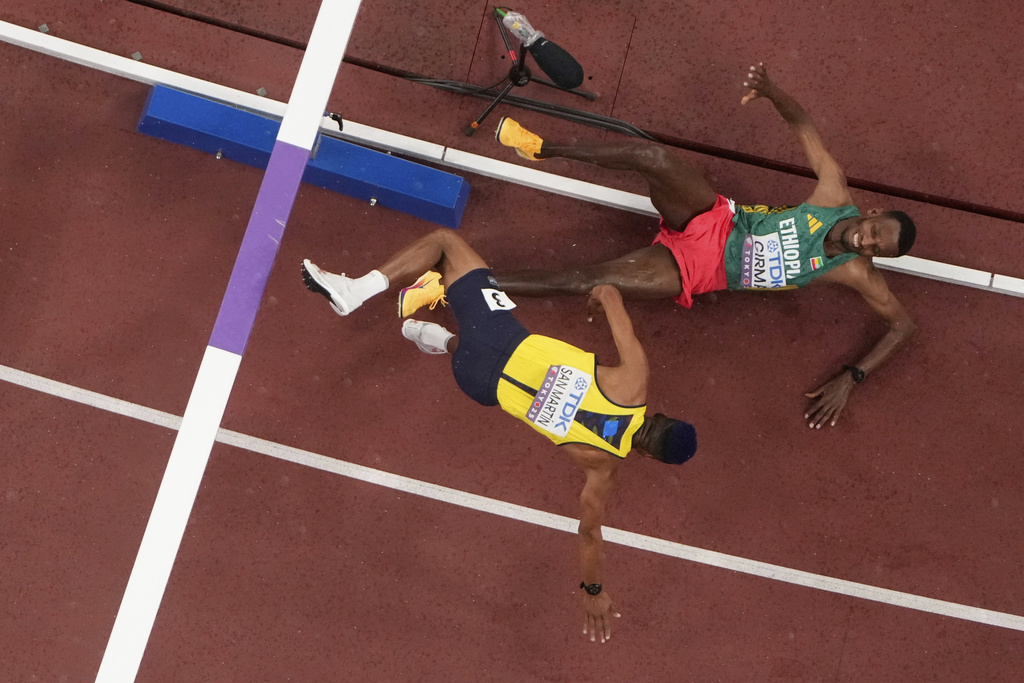 Colombia's Carlos San Martin (3) and Ethiopia's Lamecha Girma fall during a men's 3,000 meters steeplechase heat at the World Athletics Championships in Tokyo, Saturday, Sept. 13, 2025. (AP Photo/David J. Phillip)